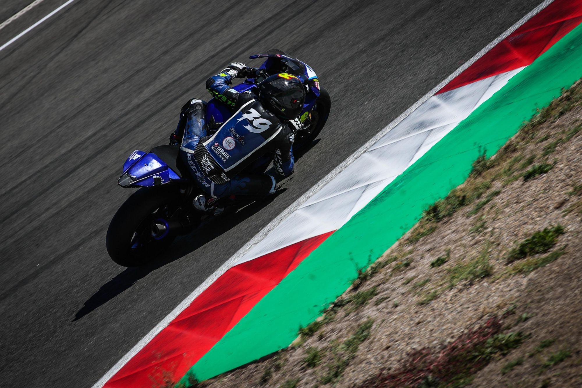 Héctor Gris tumbado en curva con su Yamaha R7 número 79, pegado al piano